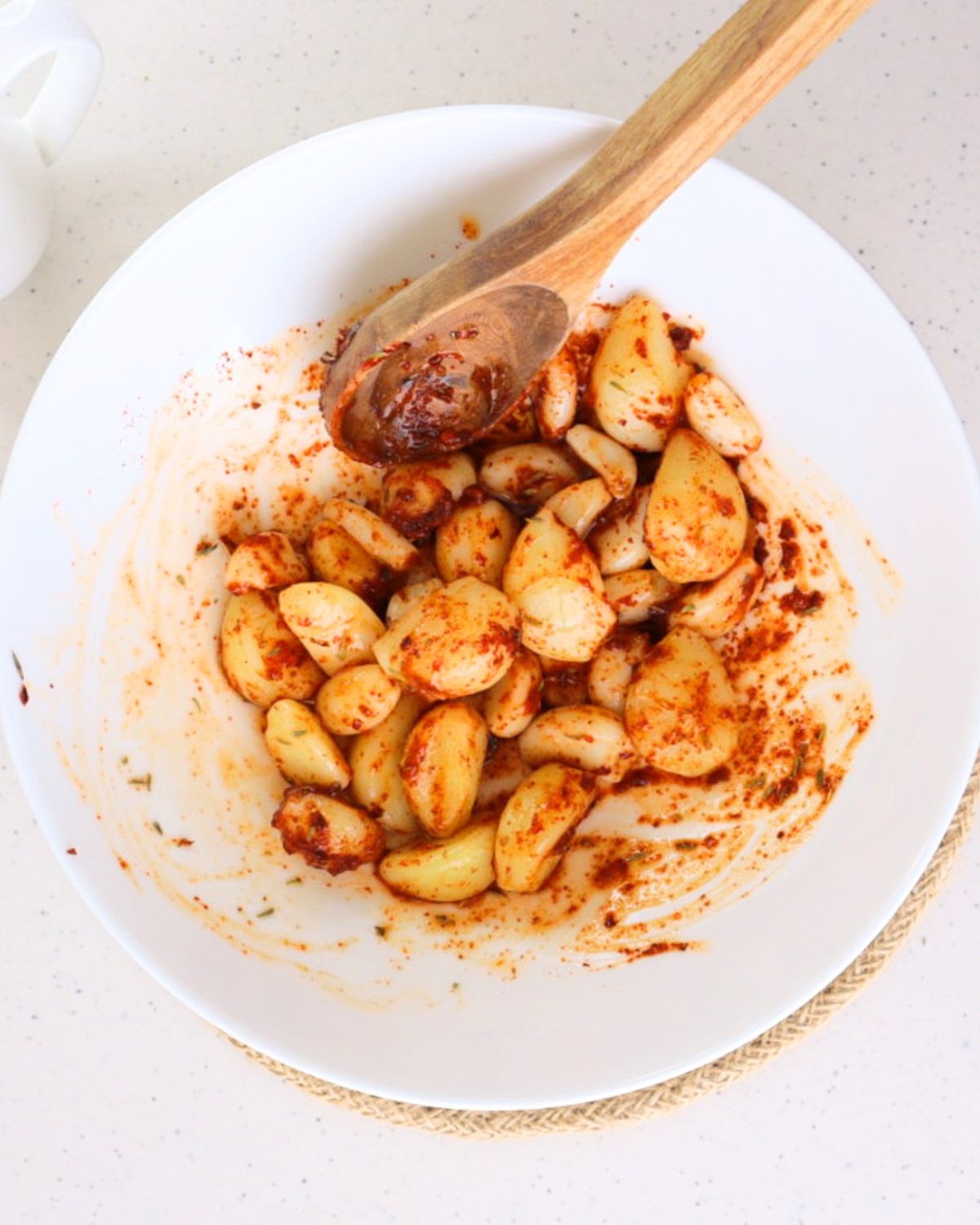 TikTok pickled garlic in a bowl with a wooden spoon. 