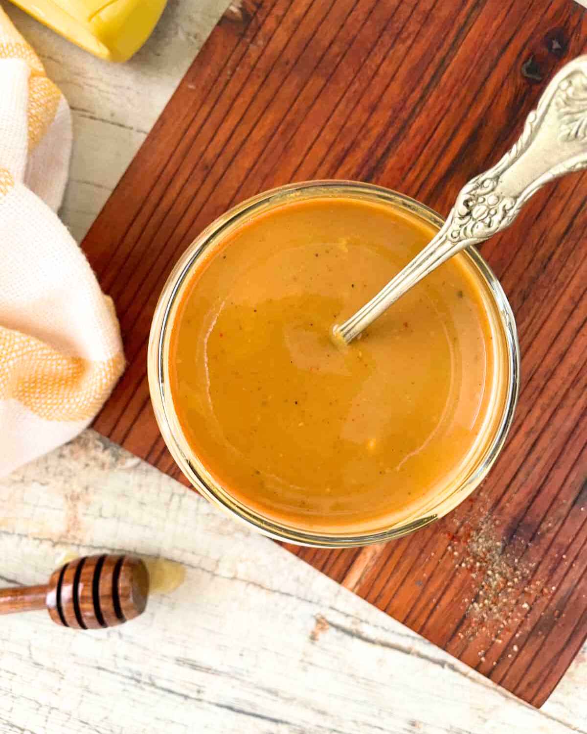 Top view image of Carolina Gold BBQ Sauce in a bowl with a silver spoon