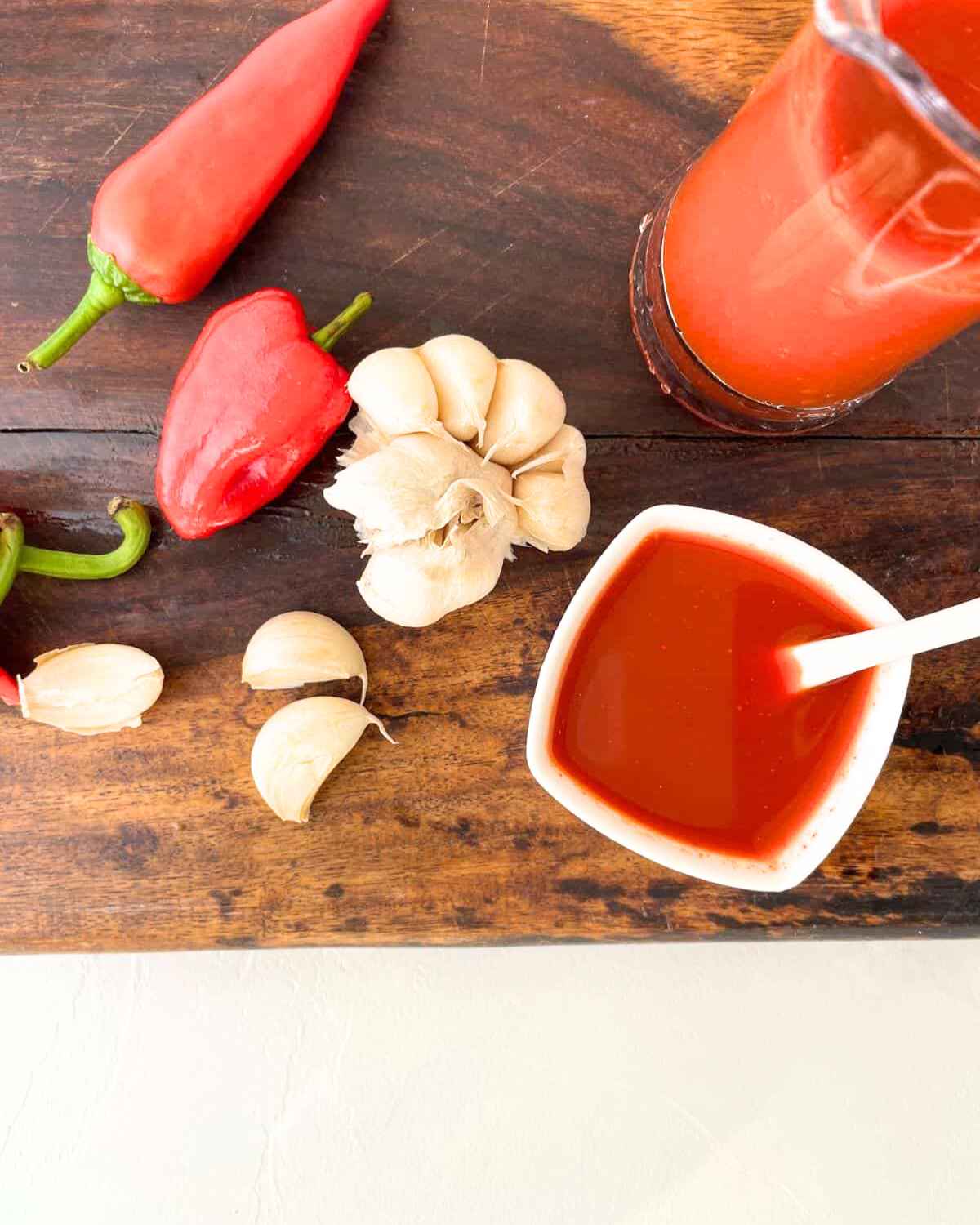 Top view image of Garlic Habanero Hot Sauce in a bowl with some raw Garlic & Habanero kept aside  