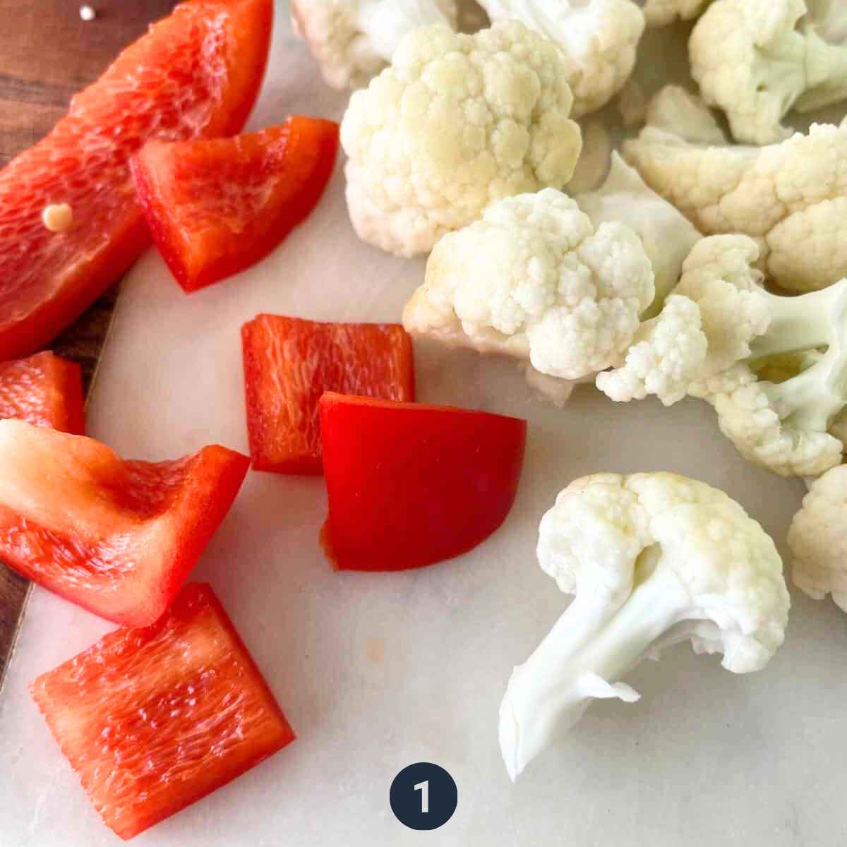 Raw vegetables being cut into pieces 