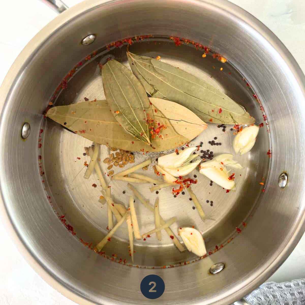 Seeds and whole spices are being boiled in a saucepan