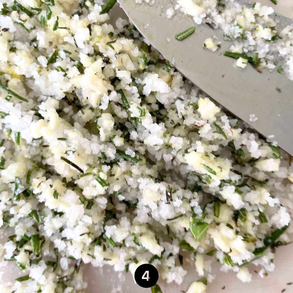 Crush the salt, garlic and herbs using the flat edge of your knife. 