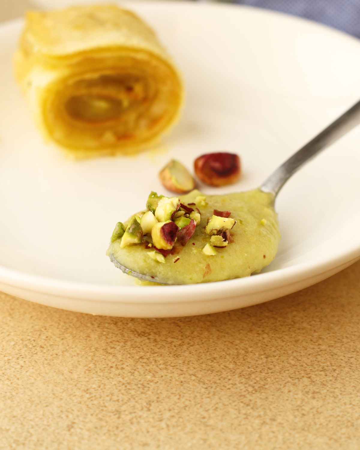 Pistachio cream in spoon with some pistachio pieces