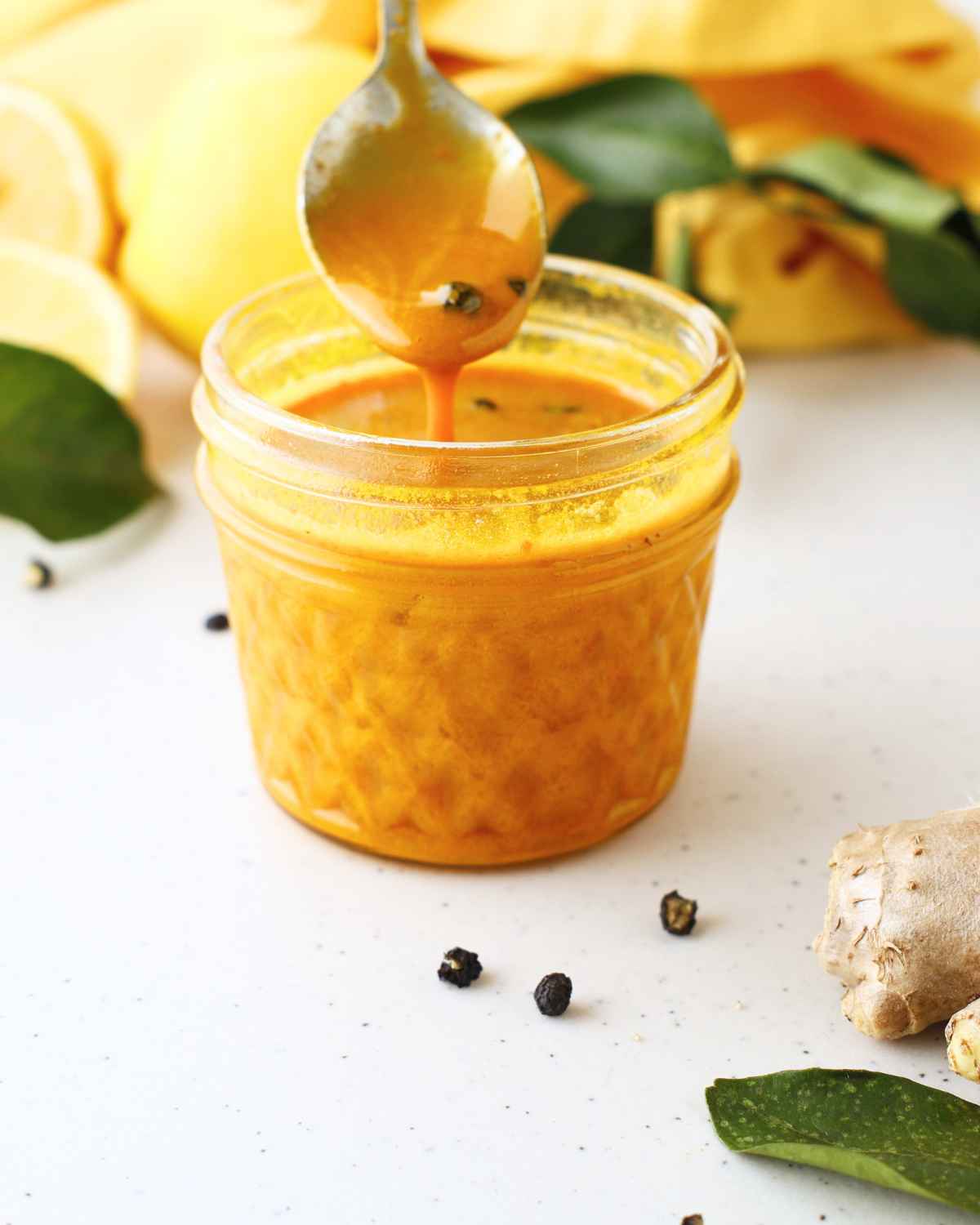 Turmeric Ginger Honey dripping from the spoon into the jar 